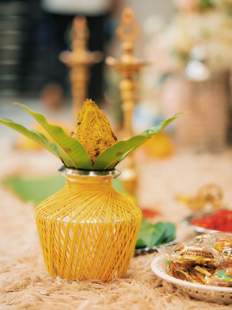 A beautifully decorated Kalash with leaves and flowers, symbolizing Indian traditions.